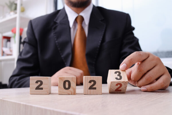 Businessman stalking wooden blocks that say 2023